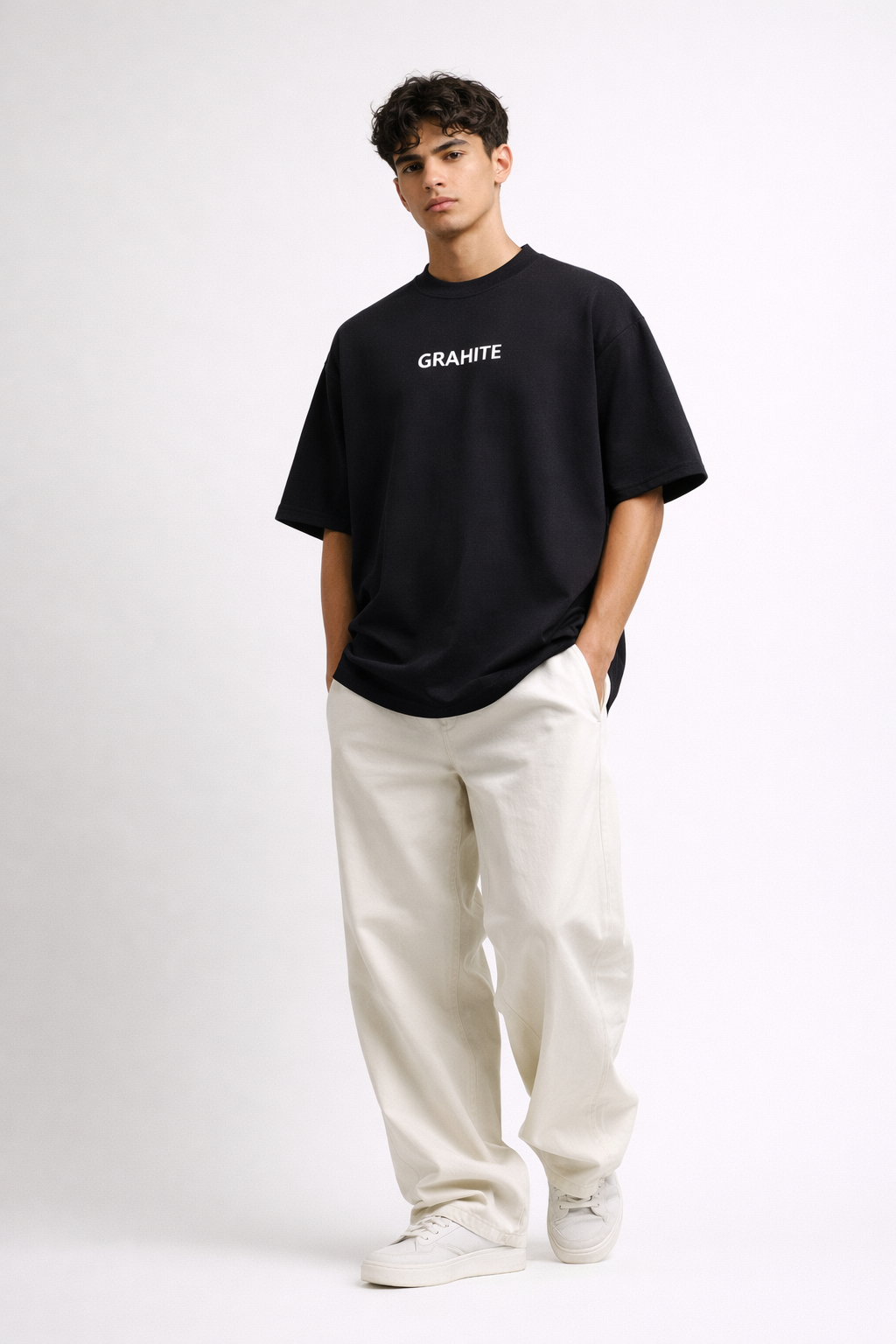Person wearing a black t-shirt with 'GRAHITE' text and white pants on a white background