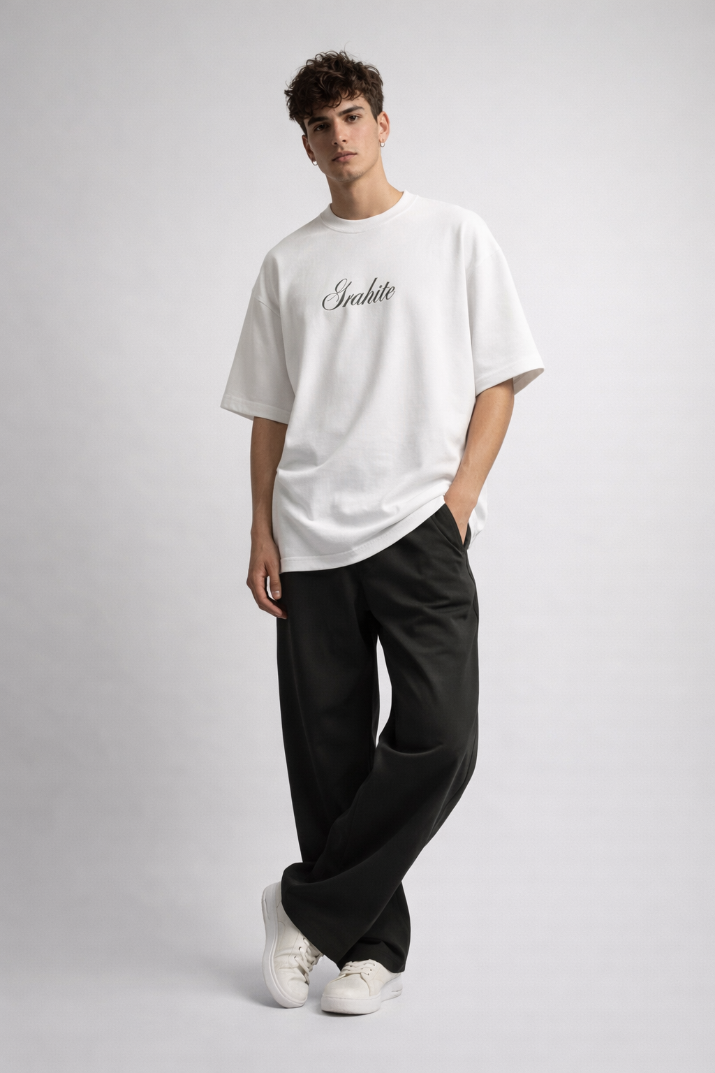 Person wearing a white t-shirt with text and black pants on a gray background