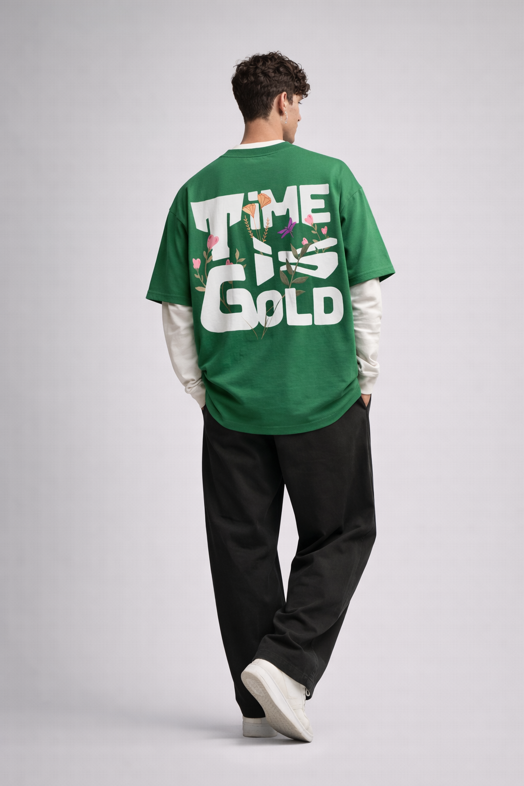 Person wearing a green sweatshirt with 'Time is Gold' text on the back, standing against a plain background.